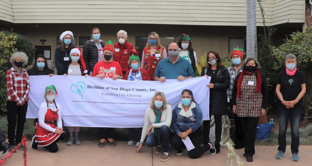 group of people in masks posing with Birthine banner